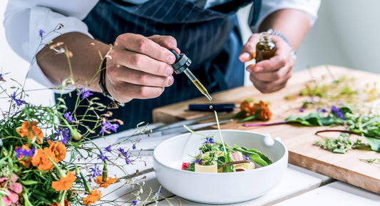 a man attending a Wellrose cooking class and adding essential oils to his food and salad.